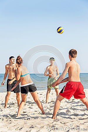 Teenages friends (four people) are playing volleyball on the beach. Editorial Stock Photo